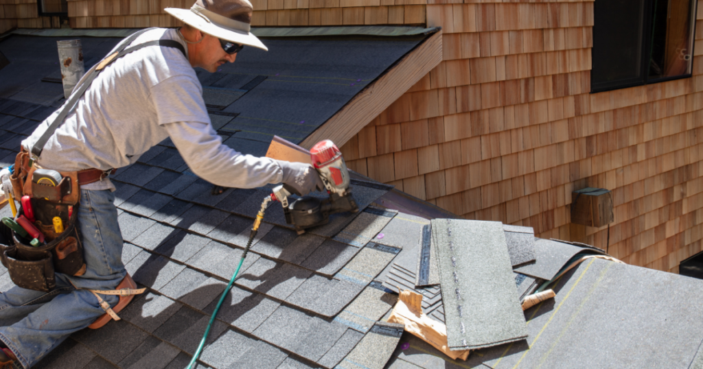 Roofer installing asphalt shingles.