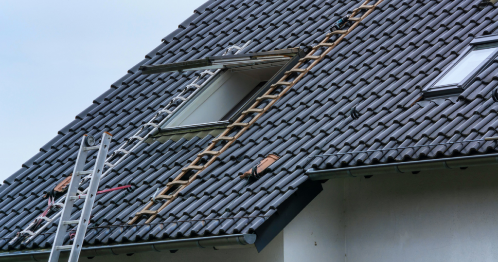 A roof window or skylight being installed on a tin roof.