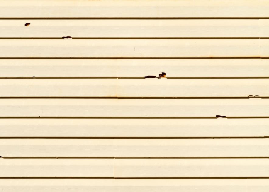 yellow vinyl siding with cracks