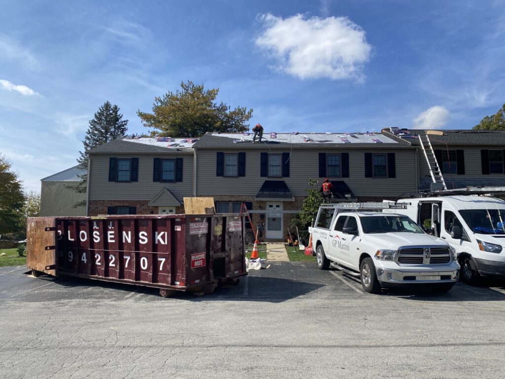 asphalt roofing installation on a two-story home.